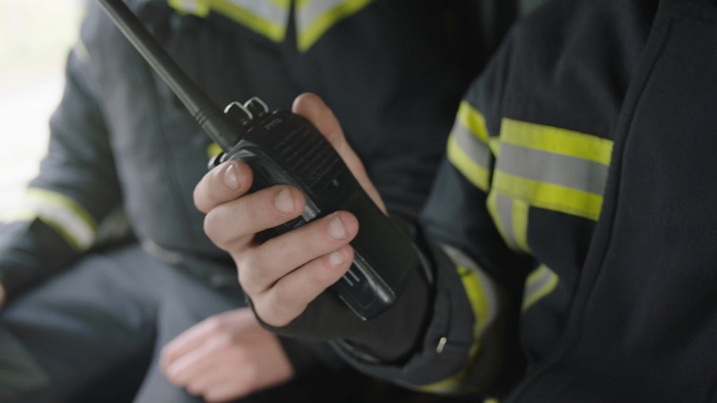 A firefighter with a walkie-talkie in hand